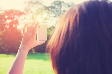 Woman taking selfie in park