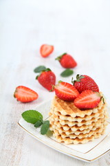 Waffles, mint and ripe strawberries.