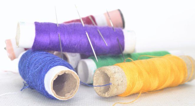 colored threads with needles and blade