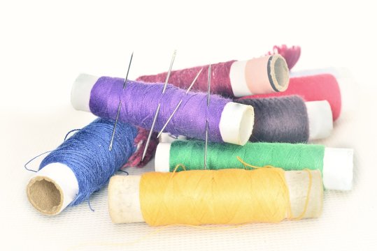 colored threads with needles and blade