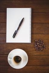 Cup of coffee and notepad with pen