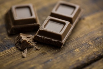 Pieces of chocolate on a wooden table