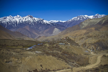 Fototapeta premium Village in the valley surrounded snowy Himalayan peaks