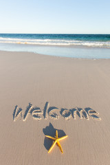 Welcome written on a beach. 