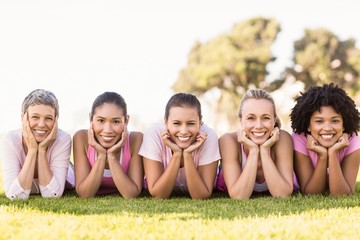 Smiling women lying in a row and wearing pink for breast cancer