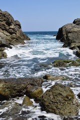 Fototapeta na wymiar 庄内浜の荒波（初夏）／山形県庄内浜の荒波風景を撮影した写真です。庄内浜は非常にきれいな白砂が広がる海岸と、奇岩怪石の磯が続く大変素晴らしい景観のリゾート地です。強風で晴天の日に、海岸で荒波を撮影した写真です。
