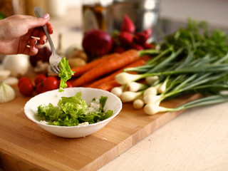 Cook's hands preparing vegetable salad - closeup shot