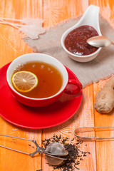 Cup of  tea with ginger,   raspberry jam and lemon