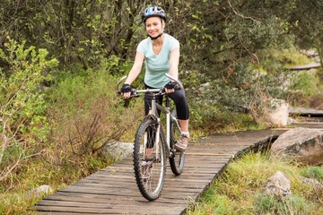 Fototapeta na wymiar Smiling fit woman cycling her bike