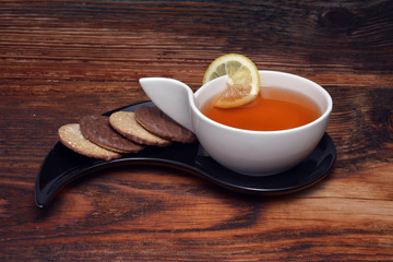 Cup of tea and crackers on wood