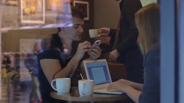 Man and woman work in the restaurant using gadgets