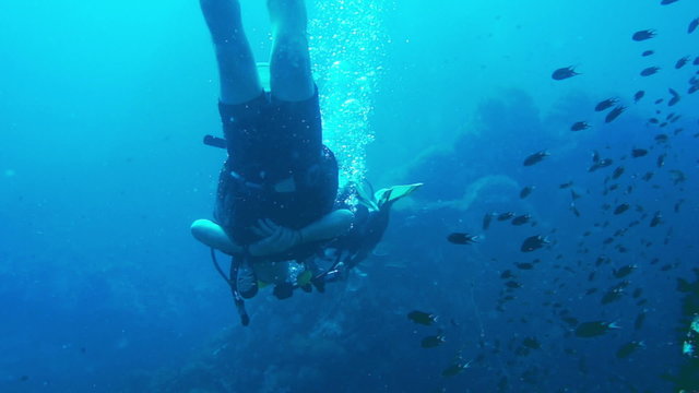 Man scuba diving trainning practice underwater with corall reef