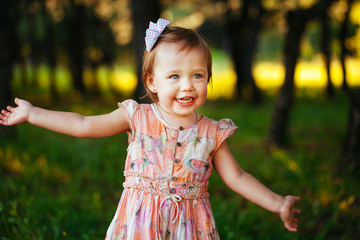 Cute little girl on the meadow in summer day.