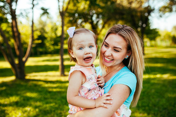 Happy mom and daughter smiling at nature.