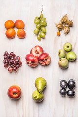 heaps of fresh summer fruits on  white wooden background, top view