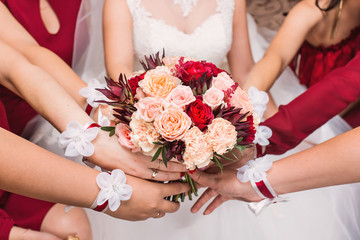 Obraz na płótnie Canvas Close-up of a bride and her bridesmaids holding bouquet.