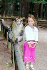 Naklejka premium Cute little girl with monkey