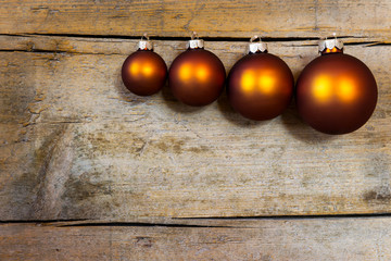 Vier Christbaumkugeln auf hölzernem Hintergrund