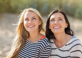 happy teenage girls or young women on beach