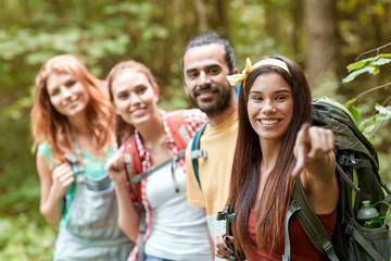 group of smiling friends with backpacks hiking