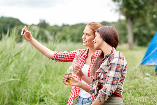 happy women taking selfie by smartphone at camping