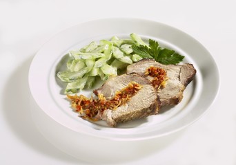 Slices of spit-roasted pork with cucumber salad