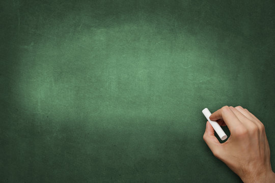 hand writes with chalk on blackboard - blank copyspace background