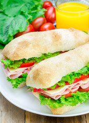 Healthy ciabatta bread sandwiches with ham and cheese on the white plate