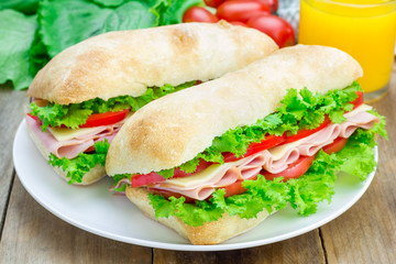 Healthy ciabatta bread sandwiches with ham and cheese on the white plate