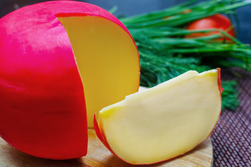 Edam cheese and a piece on cutting board