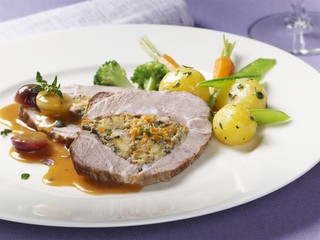 Stuffed roast pork with grape sauce and vegetables