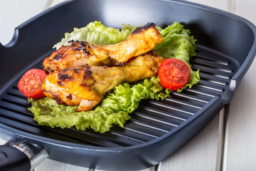 Grilling. Grilled chicken. Grilled chicken legs. Grilled chicken legs, lettuce and cherry tomatoes. Traditional cuisine. Mediterranean cuisine.
