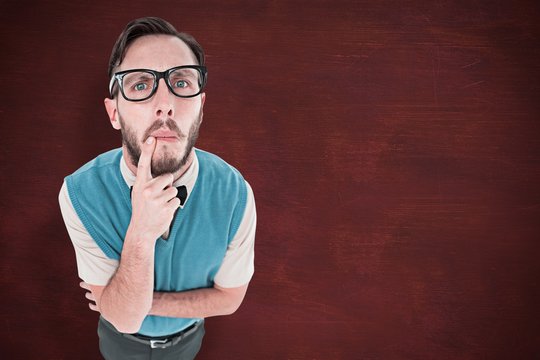 Composite image of geeky hipster looking confused at camera