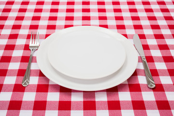 Empty white plates on checkered tablecloth © Szasz-Fabian Erika