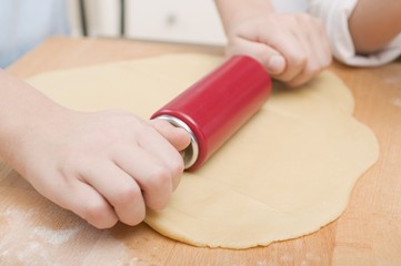 Obraz na płótnie Canvas Child rolling out dough