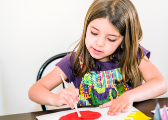 Portrait of cute girl concentrated while painting