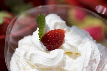 Whipped cream with a piece of strawberry on top