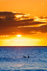 A lone surfer at sunset, Maui, Hawaii, USA