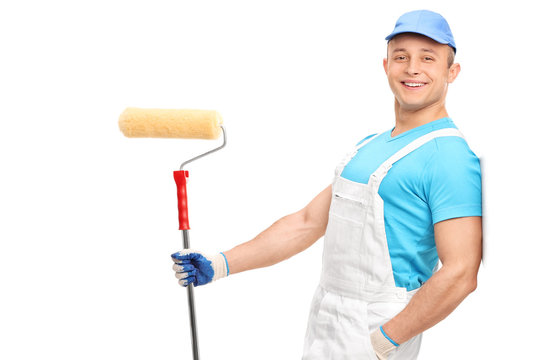 Relaxed Young Painter In A White Jumpsuit Holding A Paint Roller