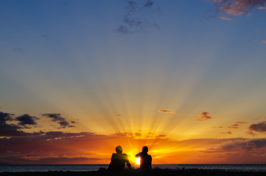Couple Watching The Sunset On A Beach In Maui Hawaii USA