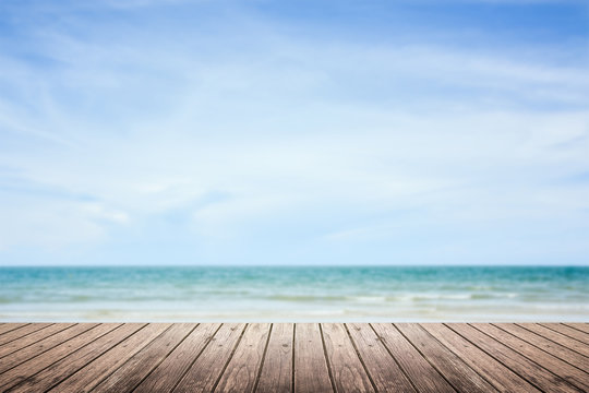 wooden floor with sea and sky blurred background