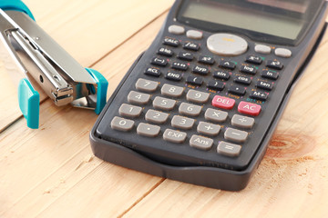 Calculator and Stapler on Wooden board