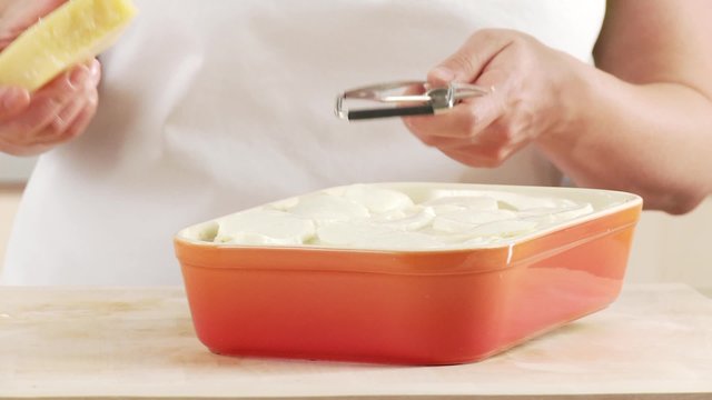Lasagne being sprinkled with freshly grated Parmesan