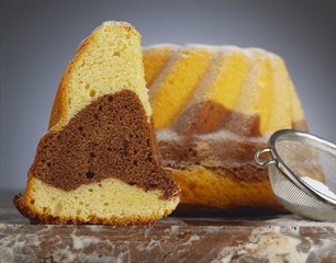 Marbled gugelhupf with icing sugar, a piece cut