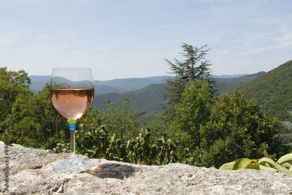 Sticker Verre de vin rosée devant un paysage de montagne