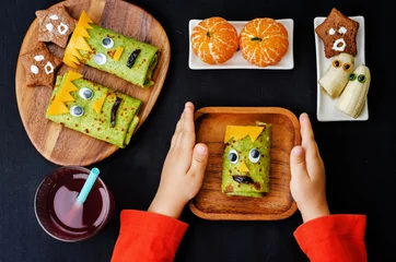 Zelfklevend Fotobehang childrens hands holding plate with lunch in the form of monsters © nata_vkusidey
