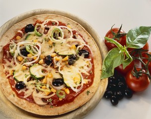 Pizza with vegetable topping and cheese on wooden board