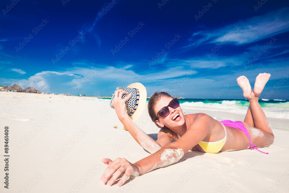 Wall mural Young woman enjoying sunny day at tropical beach