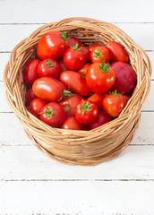 tomatoes/ red ripe tomatoes in a wicker basket on the white boards