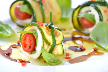 Caprese mit gebratenen Zucchinischeiben umwickelt und mit Schnittlauch gebunden, Olivenöl-Balsamico-Marinade © kab-vision